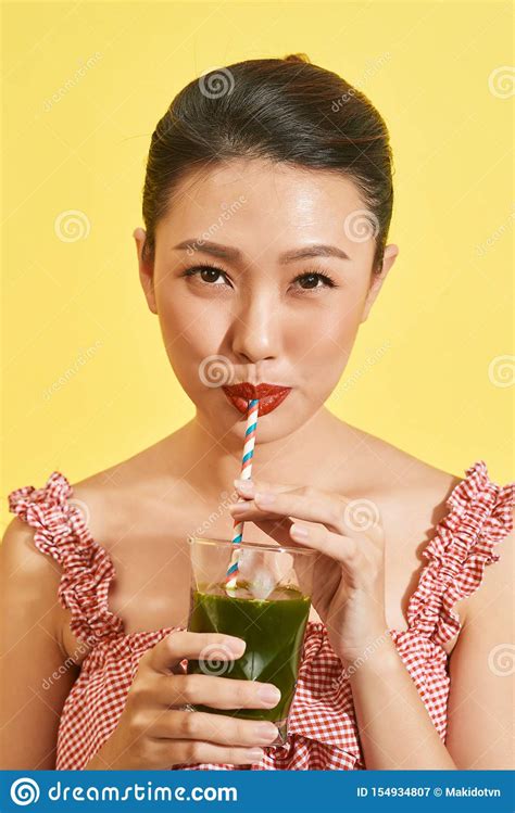 Smiling Young Asian Woman Drinking Green Fresh Vegetable Juice Or Smoothie From Glass Stock