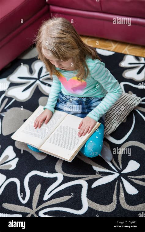 Little Girl Reading A Book At Home Stock Photo Alamy