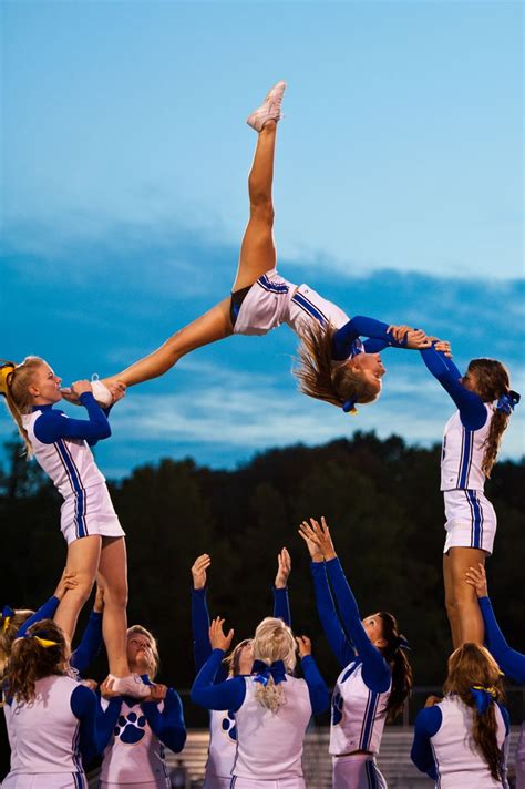A Group Of Cheerleaders Are Doing Tricks In The Air
