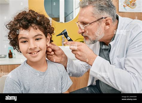 Otoscopy And Hearing Check Up For Boy At Audiology Office Pediatrician
