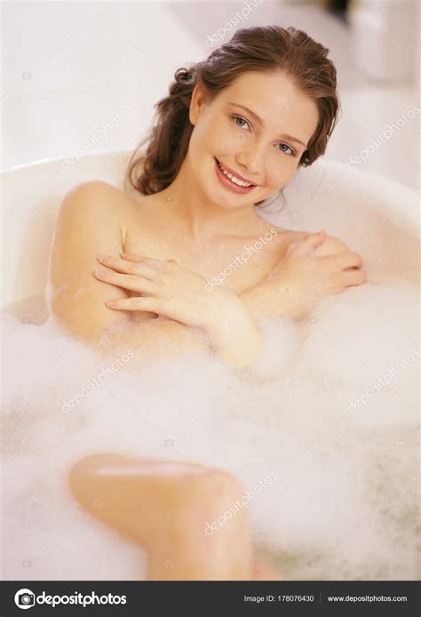 Sonriendo mujer desnuda acostada en el baño fotografía de stock ImageSource