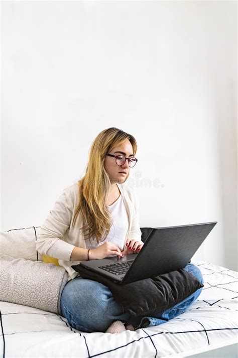 Girl Typing On Laptop While Sitting On Bed At Home Stock Photo Image