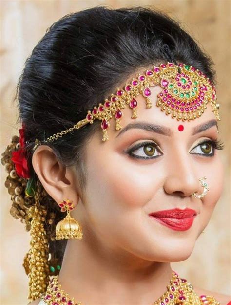 A Woman With Makeup And Jewelry On Her Face
