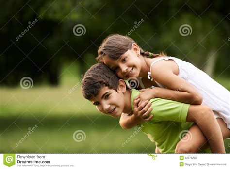 Children Boy And Girl In Love Running Piggyback Park Stock