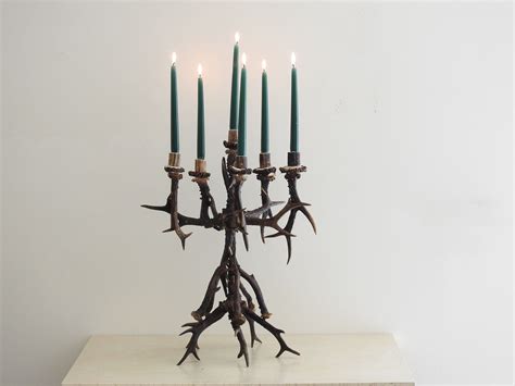 A Candle Holder Made Out Of Antler Branches With Candles In The Middle