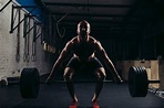 Hombre levantando pesas. entrenamiento de hombre musculoso en el ...