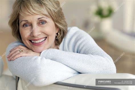 Attractive Mature Woman Smiling Looking Head In Hands Stock Photo
