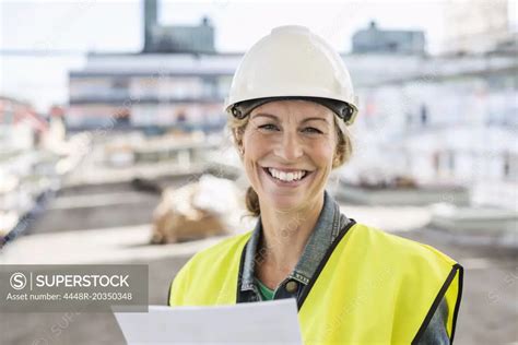 Portrait Of Happy Female Architect At Construction Site Superstock