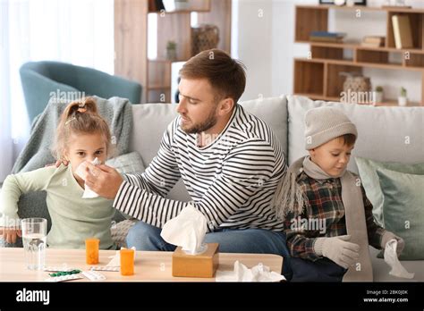Father Taking Care Of His Sick Little Children At Home Stock Photo Alamy