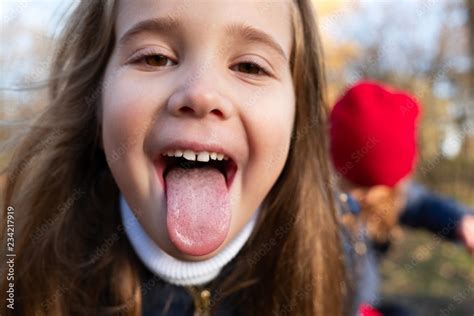 Portrait Of A Girl Sticking Tongue Out Stock Photo Adobe Stock