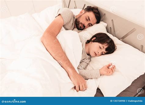 Little Son With Tired Sleeping Father In Bed Stock Photo Image Of