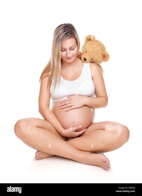 Portrait Of A Happy Pregnant Woman Sitting On Floor And Holding Belly