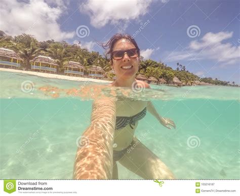 Brunette Woman In Bikini And Sunglasses Swimming Taking A Selfie Stock