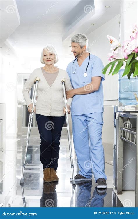 Physiotherapist Helping Senior Woman With Crutches Stock Photo Image