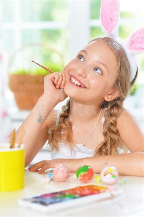 Portrait Of Beautiful Girl Painting Eggs For Easter Holiday Stock Photo