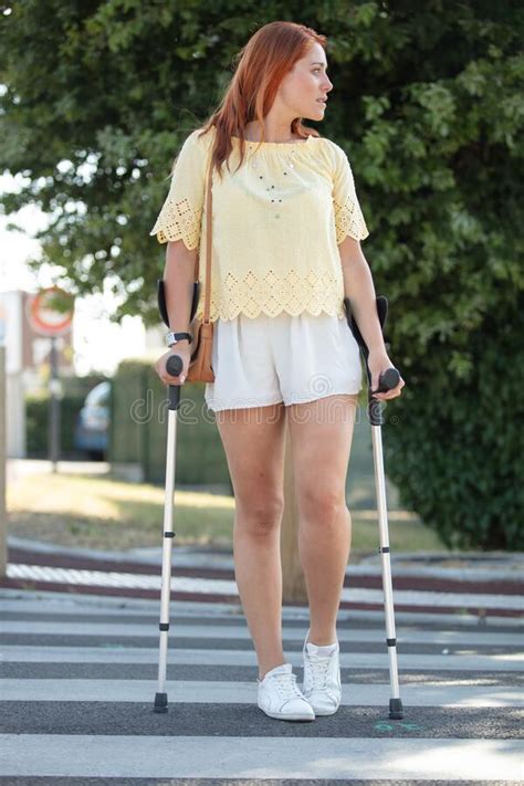Disabled Young Woman Walking On Crutches In Street Stock Photo Image