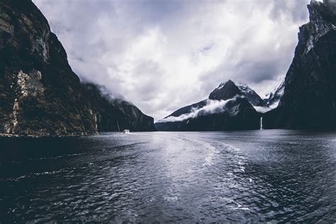 Free Photo Body Of Water Surround By Mountains Under Cloudy Sky
