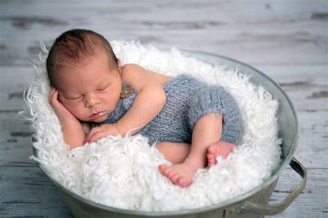 Newborn Baby Boy Sleeping Peacefully In Basket Dressed In Knit Stock
