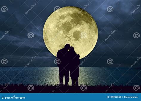 Silhouette Of Couple Embracing Standing At The Beach At Night Watching