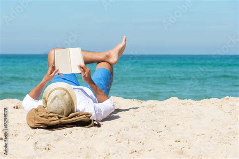A Handsome Man Relaxing On A Book Reading On The Beach Stockfotos Und Lizenzfreie Bilder Auf