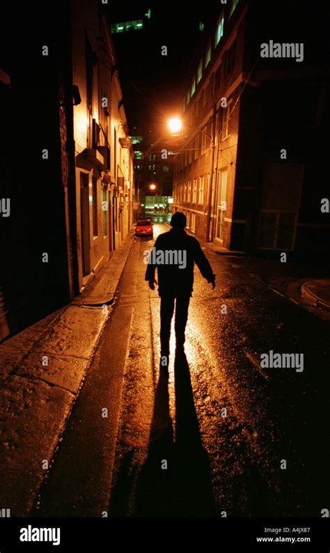 The Dark Shape Of A Man In A Lonely City Street At Night Stock Photo