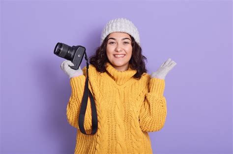 Free Photo Smiling Young Woman Holding Camera In One Hand And