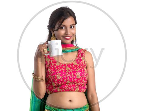 Image Of Portrait Of A Young Indian Traditional Girl Enjoying A Cup Of