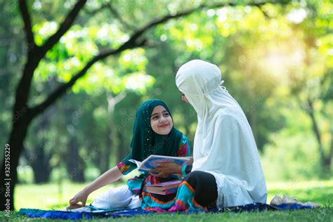 muslim mother talking about islam with adorable muslim girl in hijab at green park concept