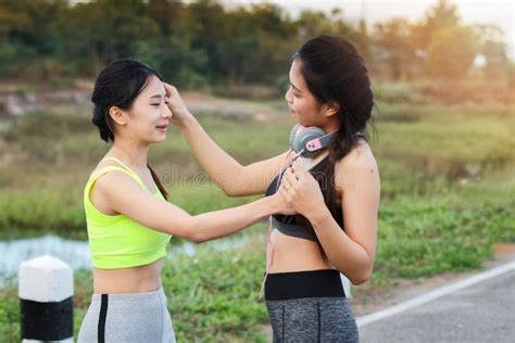 Two Sporty Girls Talking Fun And Touching Hair Relax Together In Park Stock Photo Image Of