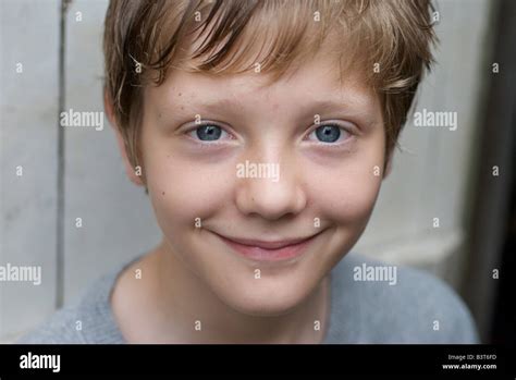 Smiling Portrait Of Twelve Year Old Boy Leaning On Garden Gate Stock