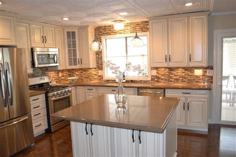A Large Kitchen With White Cabinets And Stainless Steel Appliances