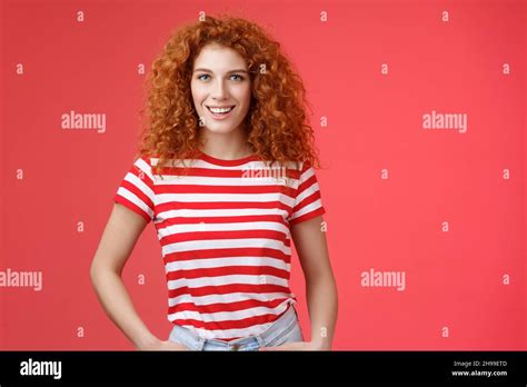 sassy confident cheeky good looking redhead curly haired woman hold hands pockets smiling daring