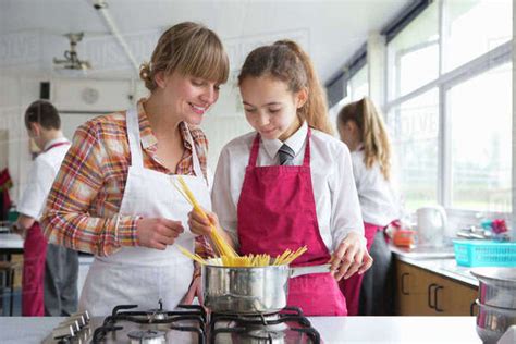 Home Economics Teacher Teaching High School Student Pasta Cooking