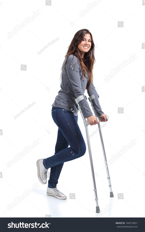 Woman Walking With Crutches On A White Isolated Background