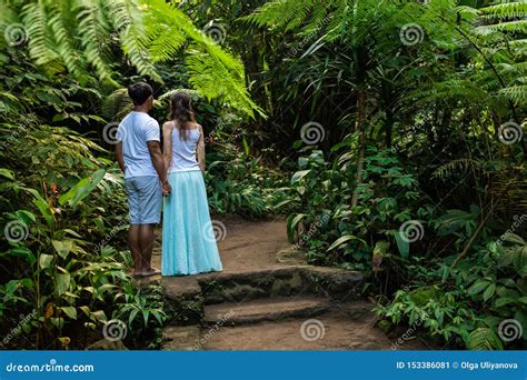 Multicultural Couple Holding Hands On Walking Trail In Tropical Forest Young Mixed Race Couple