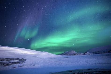 Aurora Borealis Over Snowy Mountain Landscape By Graal Publishing