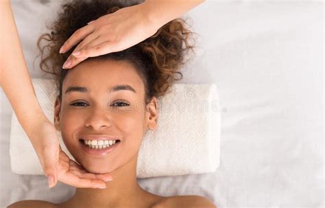 African American Woman Enjoying Face Massage At Beauty Salon Stock
