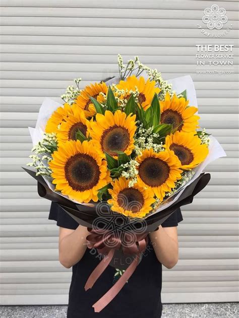 A Woman Holding A Bouquet Of Sunflowers In Her Hands