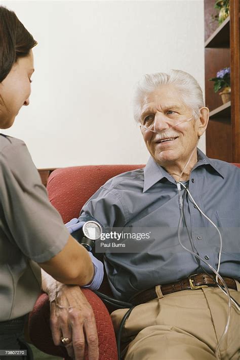 Paramedic Taking Senior Mans Blood Pressure High Res Stock Photo