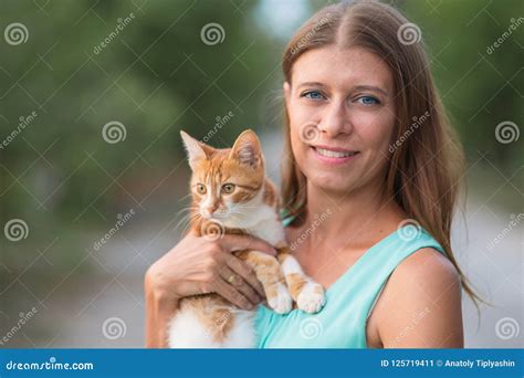 Woman Holding A Cat In Her Arms And Hugging Outdoors Stock Photo My