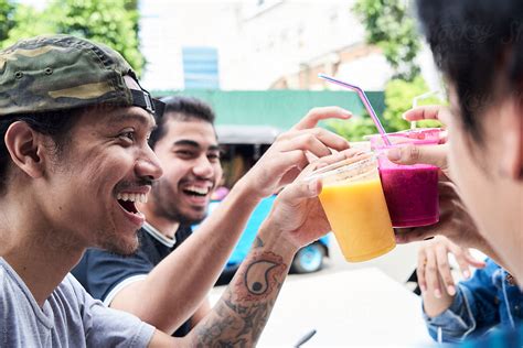 Friends Cheering With Juices Outside By Stocksy Contributor Ivan