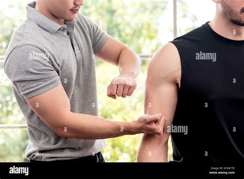 therapist giving massage to athlete male patient by beating and pounding techniques in clinic
