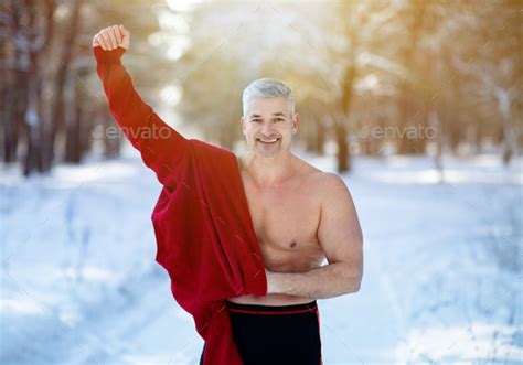 cold exposure training and acclimation concept happy mature man taking off his warm clothes at