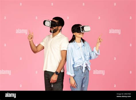 Millennial Couple Enjoying Virtual Reality Experience Pink Background