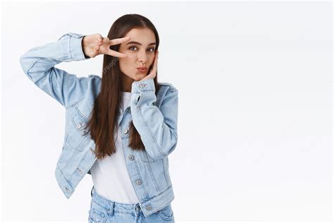 Premium Photo Coquettish Feminine Goodlooking Brunette Woman In Denim Outfit Showing Peace Or