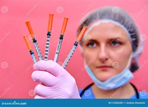 Portrait Of A Doctor Woman In A Medical Beret With Syringes In Her