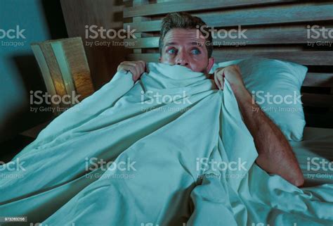 Sleepless Young Man Lying In Bed Stressed And Scared Suffering