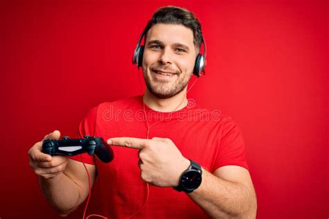 Young Gamer Man With Blue Eyes Playing Video Games Using Gamepad