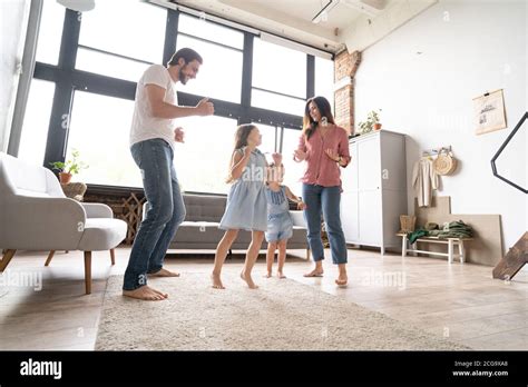 Feliz Familia Madre Padre Y Niño Hija Bailando En Casa Fotografía De