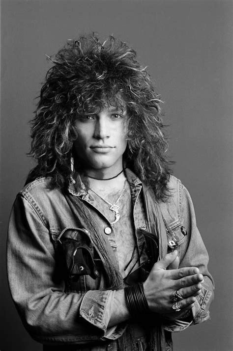 A Black And White Photo Of A Man With Long Hair Wearing A Denim Jacket